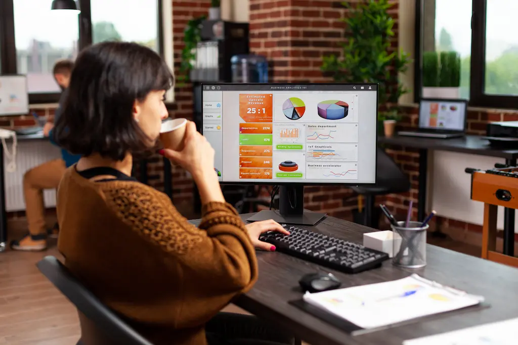 Digital marketing professional at Calectia analyzing social media performance reports on a computer.