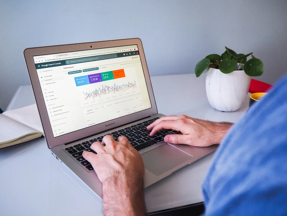 SEO for Startup: Illustration of a startup founder working on a laptop, looking at rising website rankings on Google.